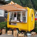 yellow round coffee trailer